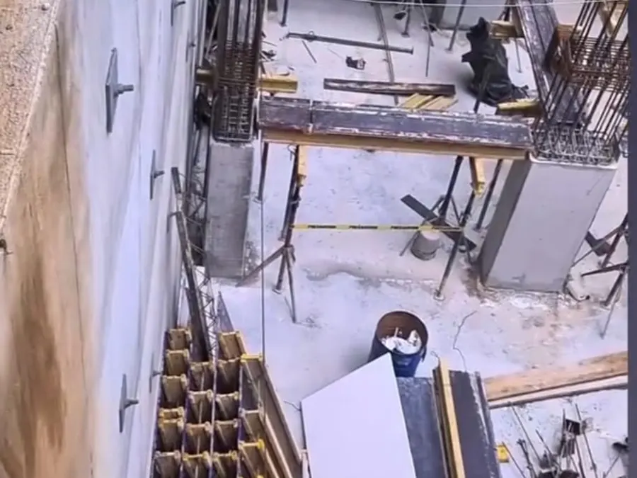 Nivel de edificio en obra gris con puntales telescópicos sosteniendo vigas y formaleta, zona 10