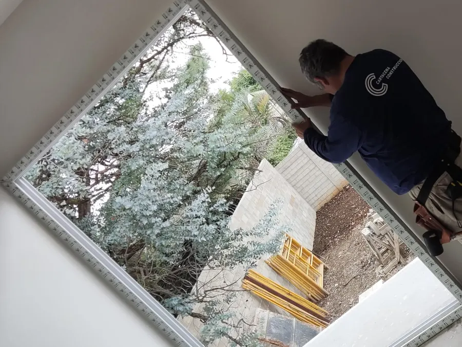 Instalación de ventanería en una casa habitacional en acabados, con andamios en el jardín, Vista al Valle
